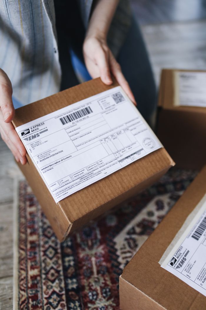 Home Close-up of hands holding a package with a visible shipping label, perfect for delivery themes.